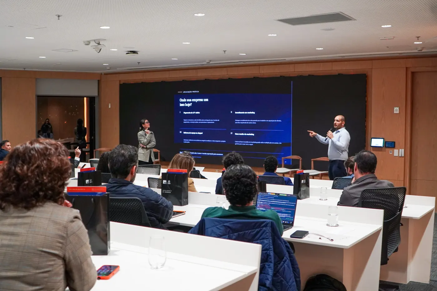 Palestrantes apresentando para uma sala cheia na XP Investimentos